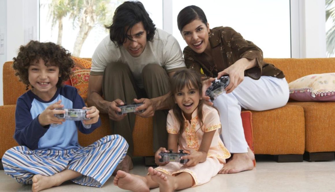 Parents playing video game with son and daughter (7-9) smiling